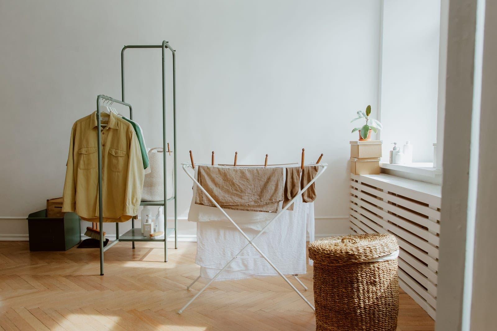 Laundry drying on a rack beside a bright window